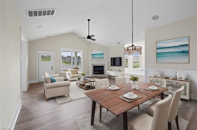 dining area featuring ceiling fan, lofted ceiling, and hardwood / wood-style floors