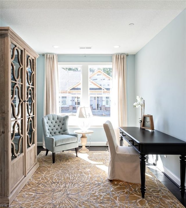 office with a textured ceiling, dark hardwood / wood-style flooring, and plenty of natural light