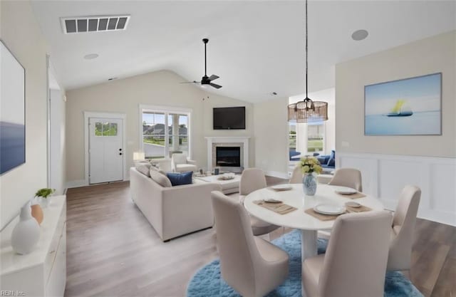 dining room featuring ceiling fan, lofted ceiling, and light hardwood / wood-style flooring