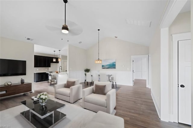 living room featuring lofted ceiling, ceiling fan, dark wood-type flooring, and sink