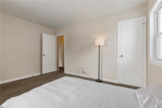 bedroom with multiple windows and dark carpet