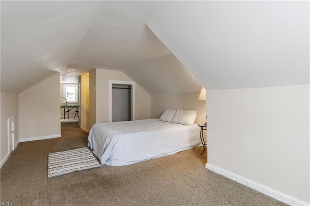 bedroom featuring lofted ceiling and carpet