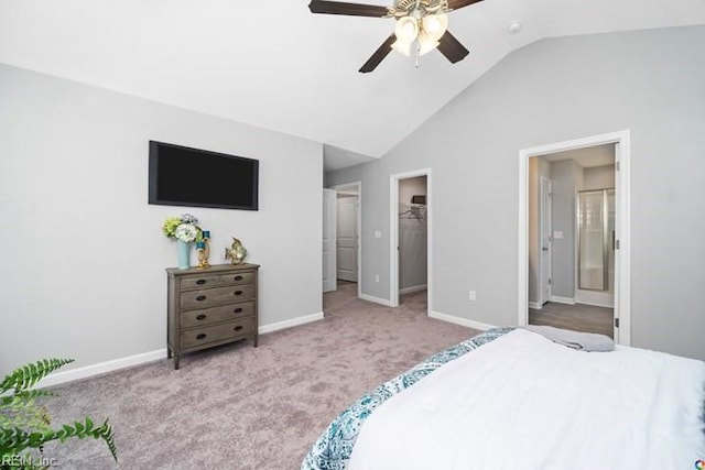 carpeted bedroom with a spacious closet, ceiling fan, connected bathroom, a closet, and vaulted ceiling