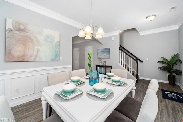 dining area with dark wood-type flooring, crown molding, and a chandelier