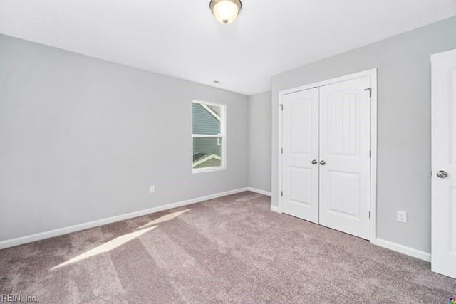 unfurnished bedroom featuring a closet and light carpet