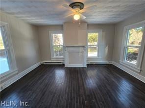 unfurnished living room with a healthy amount of sunlight and dark hardwood / wood-style floors