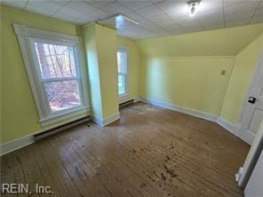 additional living space featuring a baseboard heating unit and hardwood / wood-style floors