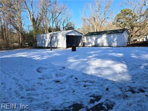 snowy yard featuring a storage unit