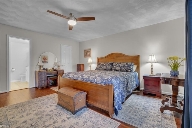 bedroom with ceiling fan, wood-type flooring, and ensuite bath