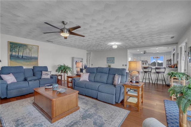 living room with ceiling fan and light wood-type flooring