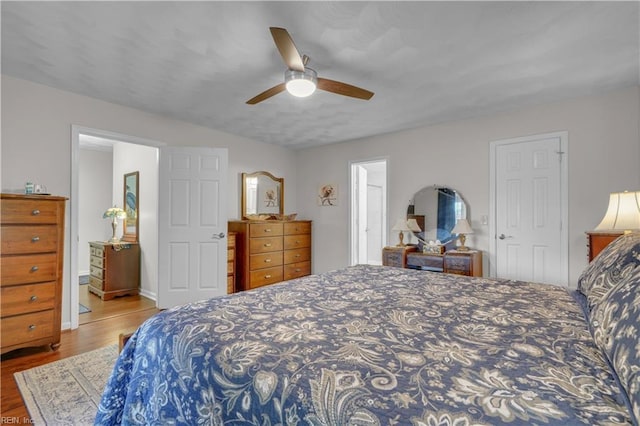 bedroom with ceiling fan, ensuite bath, and light hardwood / wood-style flooring