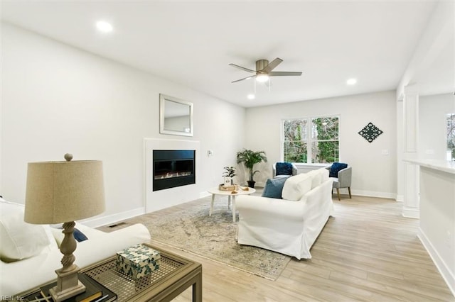 living room featuring ceiling fan and light hardwood / wood-style flooring