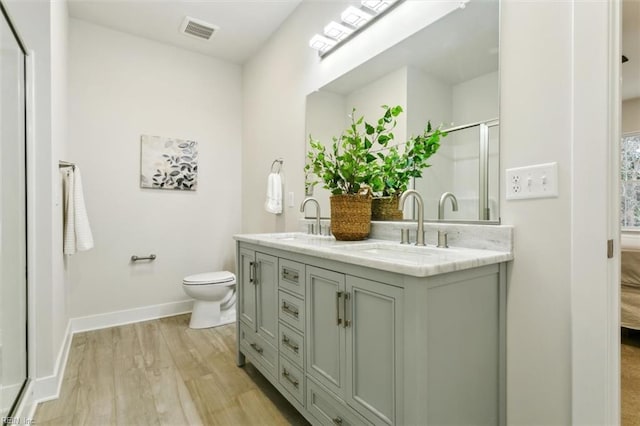 bathroom with vanity, toilet, a shower with door, and hardwood / wood-style floors