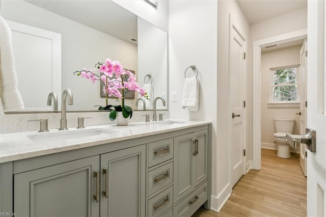 bathroom featuring hardwood / wood-style flooring, vanity, and toilet