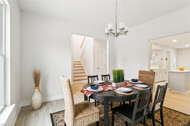 dining area with an inviting chandelier and light wood-type flooring