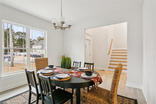 dining room with plenty of natural light, a chandelier, and wood-type flooring