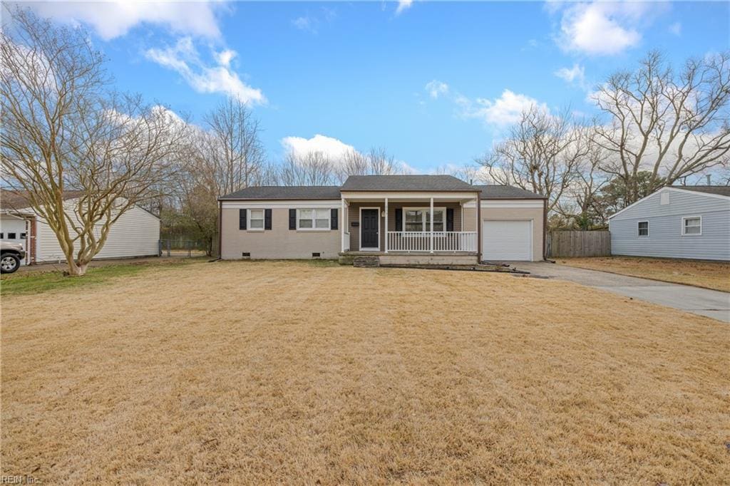 view of front of property featuring a front yard, covered porch, and a garage