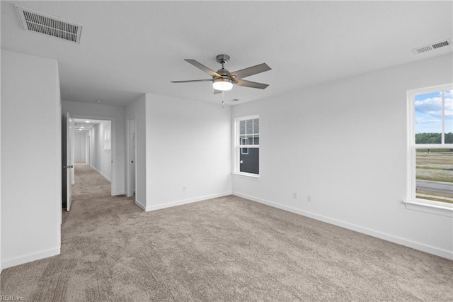 spare room with ceiling fan and light colored carpet