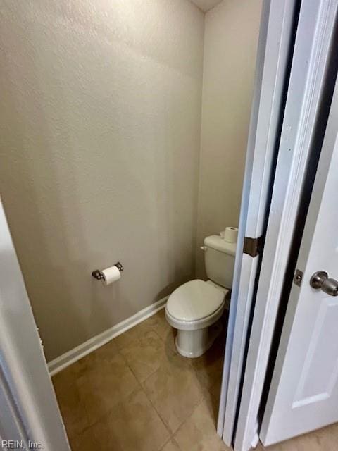 bathroom with toilet and tile patterned flooring