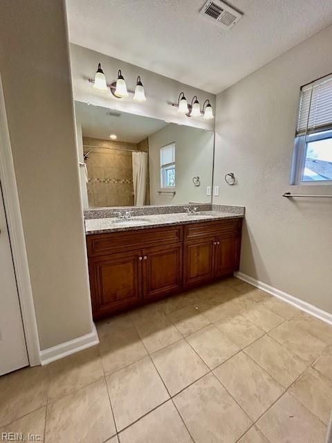 bathroom with vanity, tile patterned floors, a shower with shower curtain, and a textured ceiling