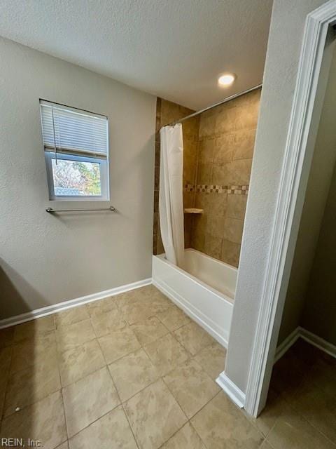 bathroom featuring a textured ceiling, shower / bathtub combination with curtain, and tile patterned floors