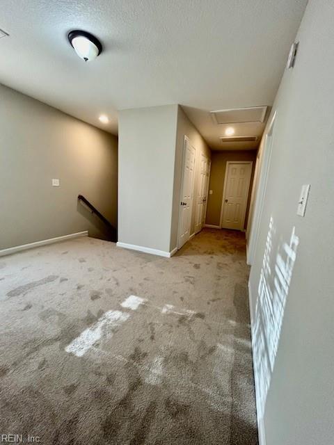 interior space featuring light colored carpet and a textured ceiling