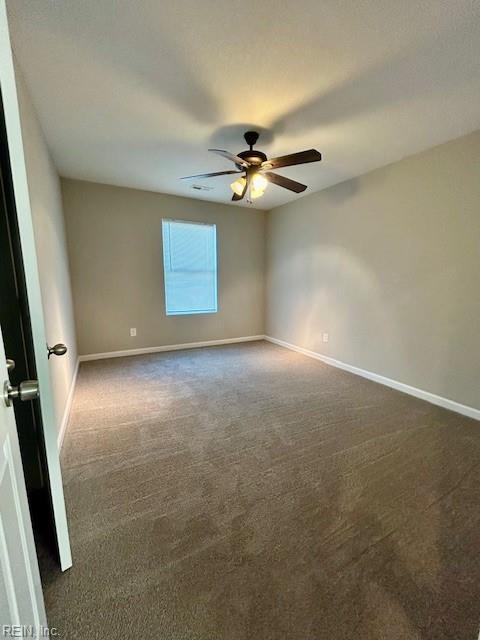 carpeted spare room with ceiling fan