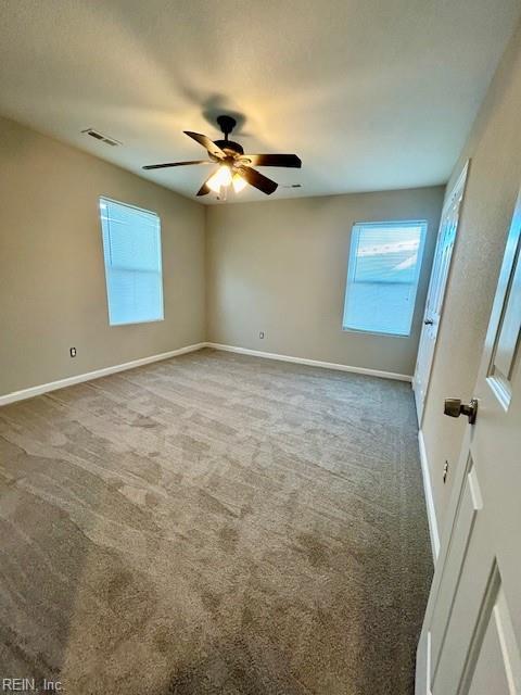 carpeted spare room featuring ceiling fan