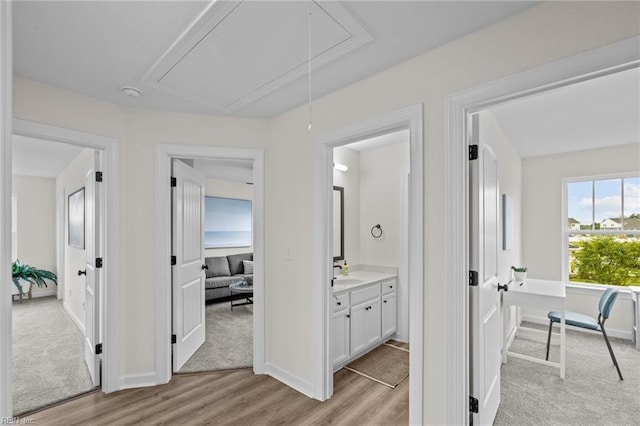 hall with sink and light wood-type flooring