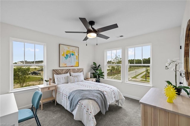 bedroom with multiple windows, ceiling fan, and carpet flooring