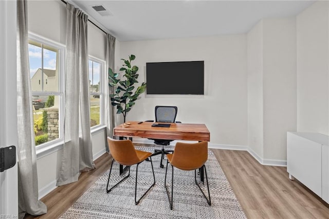 home office featuring light hardwood / wood-style floors and a healthy amount of sunlight