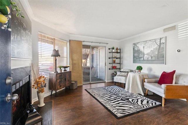 sitting room featuring dark hardwood / wood-style floors, crown molding, and a premium fireplace