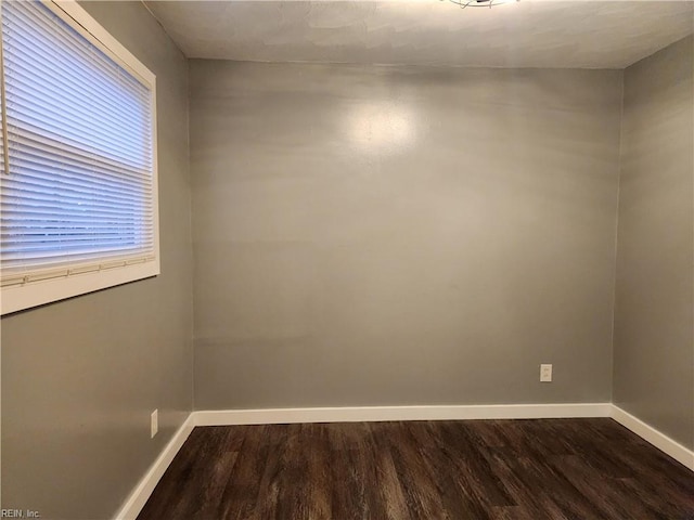 spare room with dark wood-type flooring