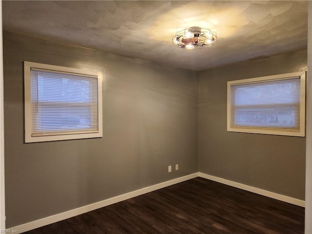 spare room with dark hardwood / wood-style floors