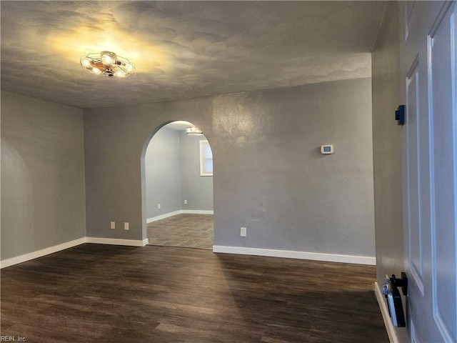 unfurnished room with dark wood-type flooring