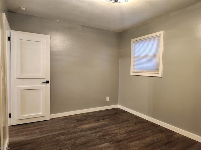 spare room with dark wood-type flooring