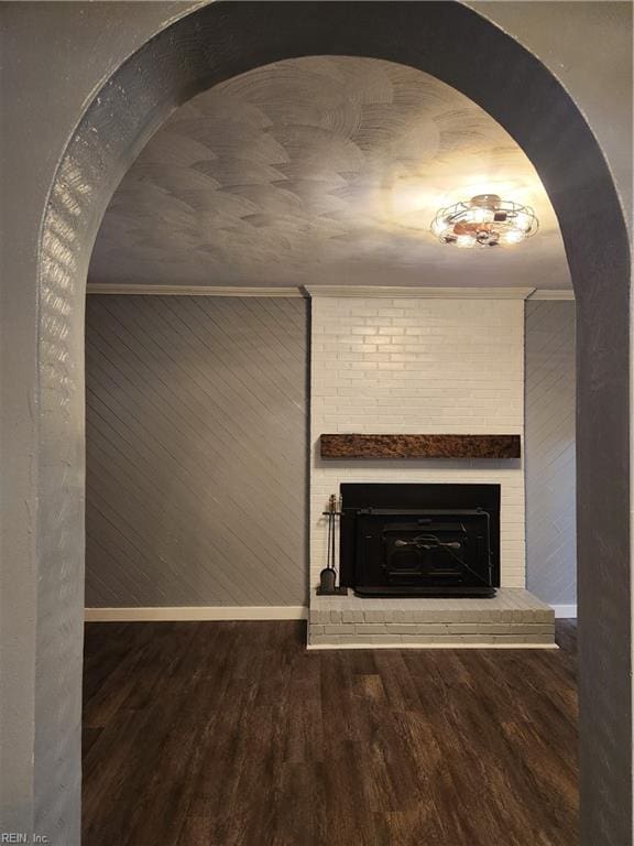 room details with hardwood / wood-style flooring, ornamental molding, a fireplace, and wood walls