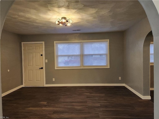 unfurnished room featuring dark wood-type flooring