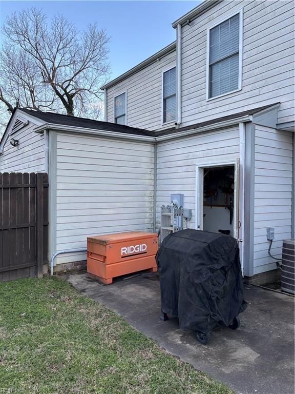 back of property featuring cooling unit and a yard