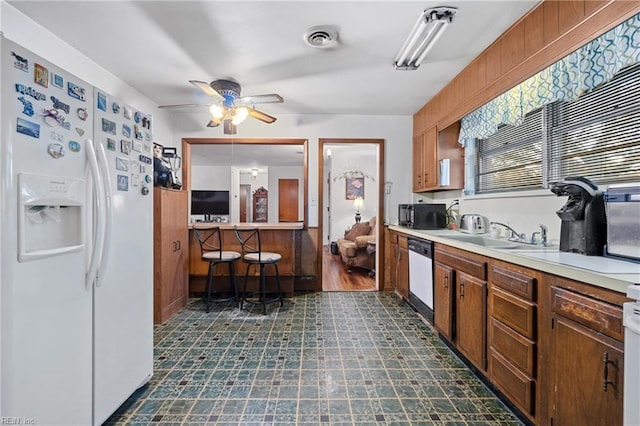 kitchen featuring sink, range, dishwasher, ceiling fan, and white refrigerator with ice dispenser