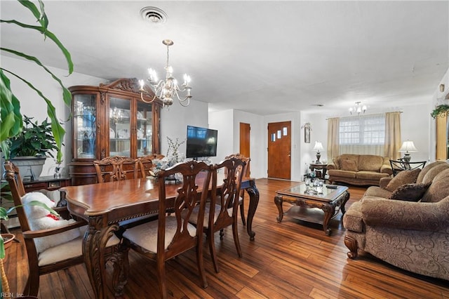 dining area with hardwood / wood-style flooring and a chandelier