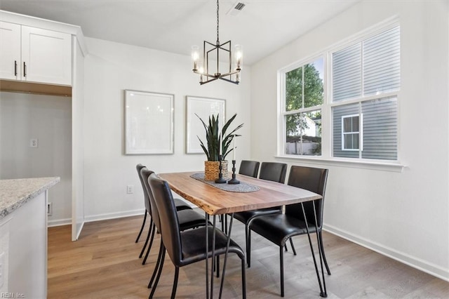 dining room with a chandelier and light wood-type flooring