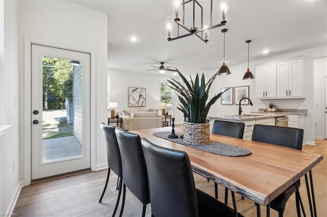 dining room with light hardwood / wood-style floors, sink, and ceiling fan