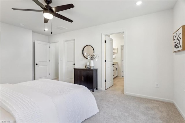 bedroom featuring ceiling fan, light colored carpet, and connected bathroom