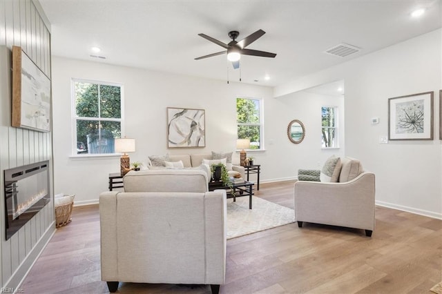 living room with ceiling fan, a healthy amount of sunlight, and light wood-type flooring