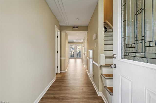 corridor with french doors and hardwood / wood-style floors