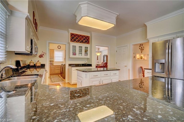 kitchen featuring dark stone countertops, sink, white cabinetry, ornamental molding, and stainless steel appliances