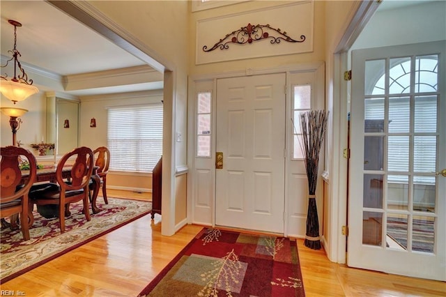 foyer featuring crown molding and light hardwood / wood-style floors