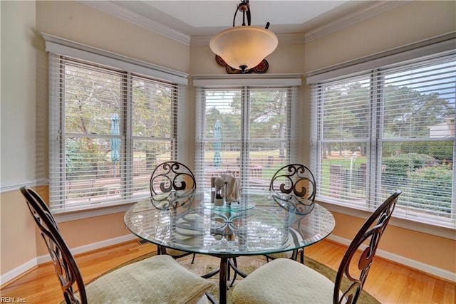 dining room with crown molding and light hardwood / wood-style flooring