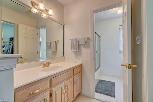 bathroom featuring bath / shower combo with glass door, vanity, and tile patterned flooring